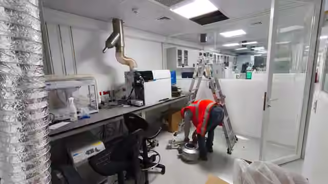 Intervención en laboratorio con ductos, equipo de extracción y personal en labores de montaje