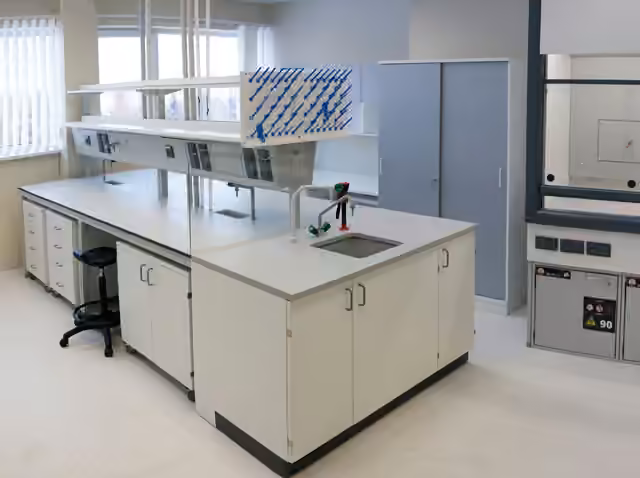 Isla de laboratorio con panel elevado, tomas, escurridor, lavatorio y gabinetes inferiores